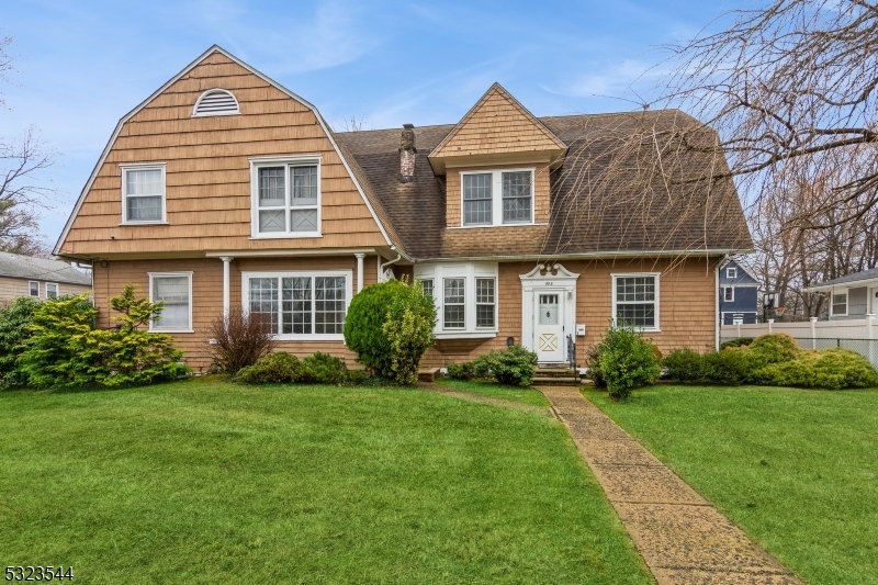 a front view of a house with a yard and trees