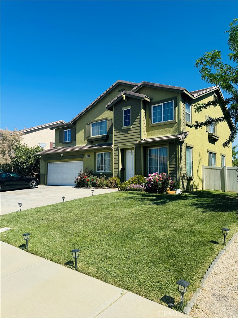 a view of a house with a yard and sitting area