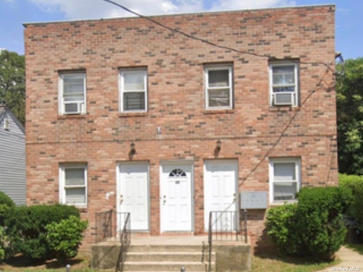 front view of a brick house with a large windows