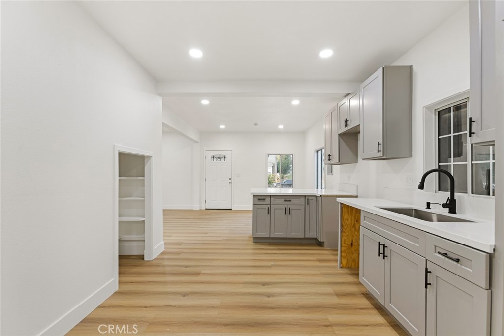 a large white kitchen with sink and white stainless steel appliances