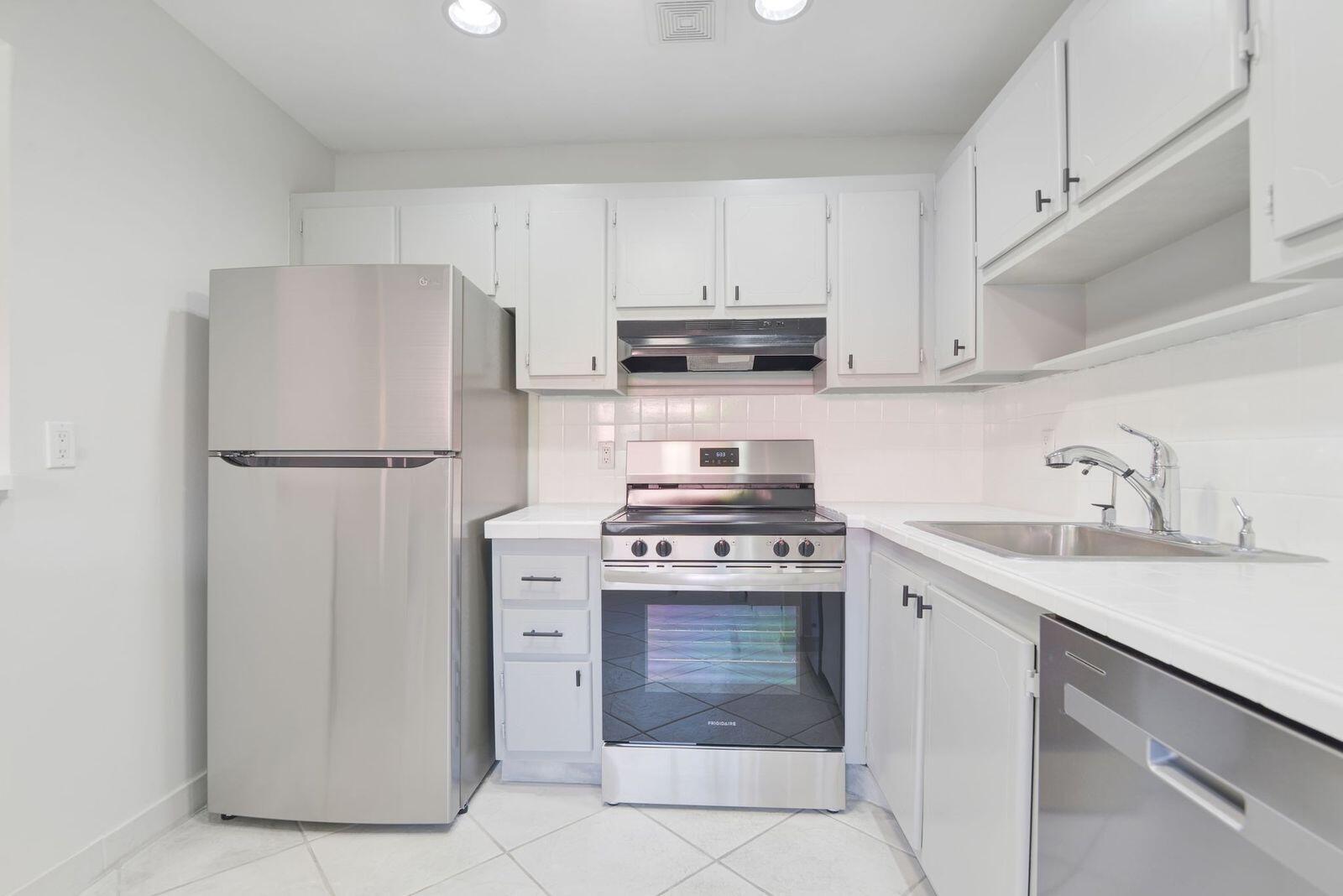 a kitchen with a stove sink and refrigerator