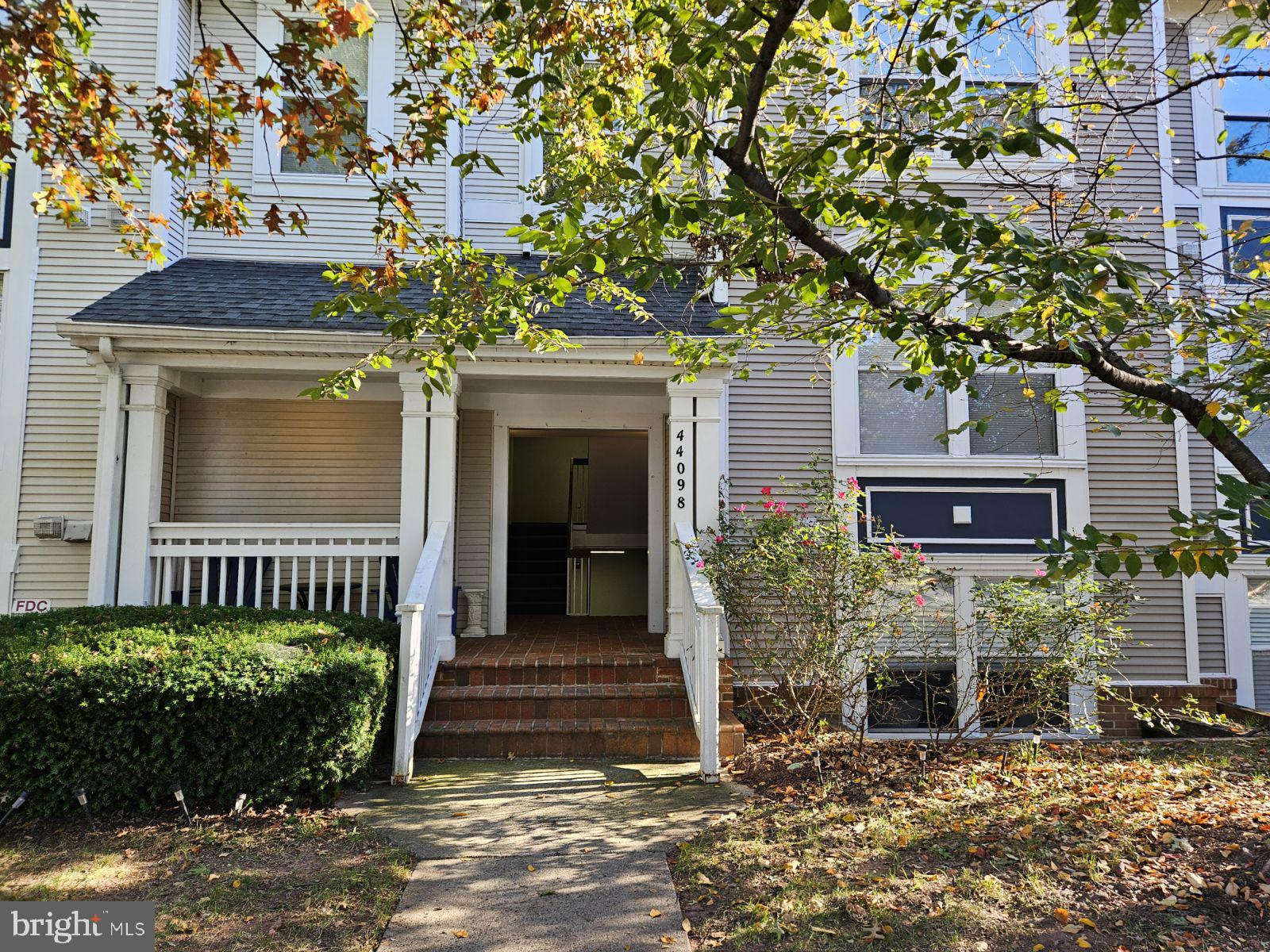 a front view of a house with a tree