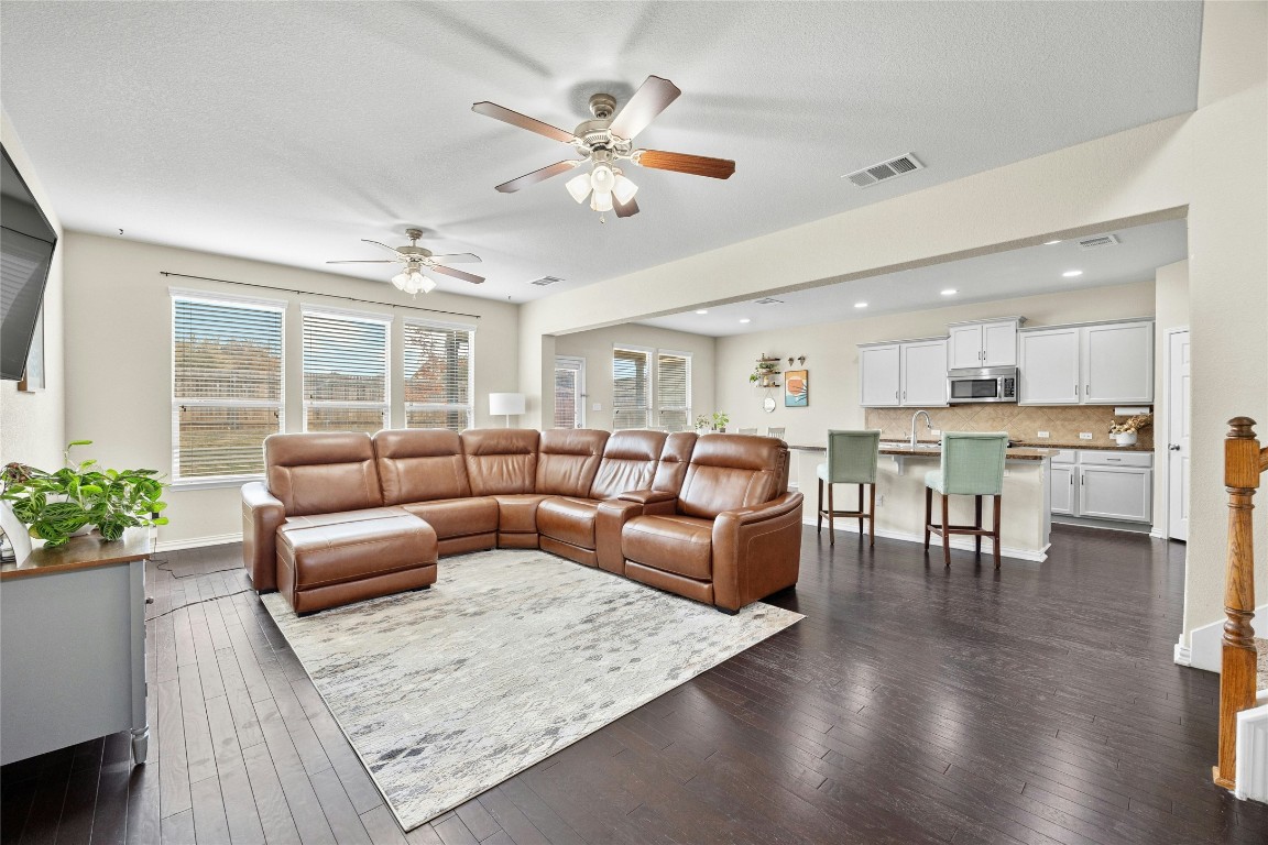 a living room with furniture kitchen view and a potted plant