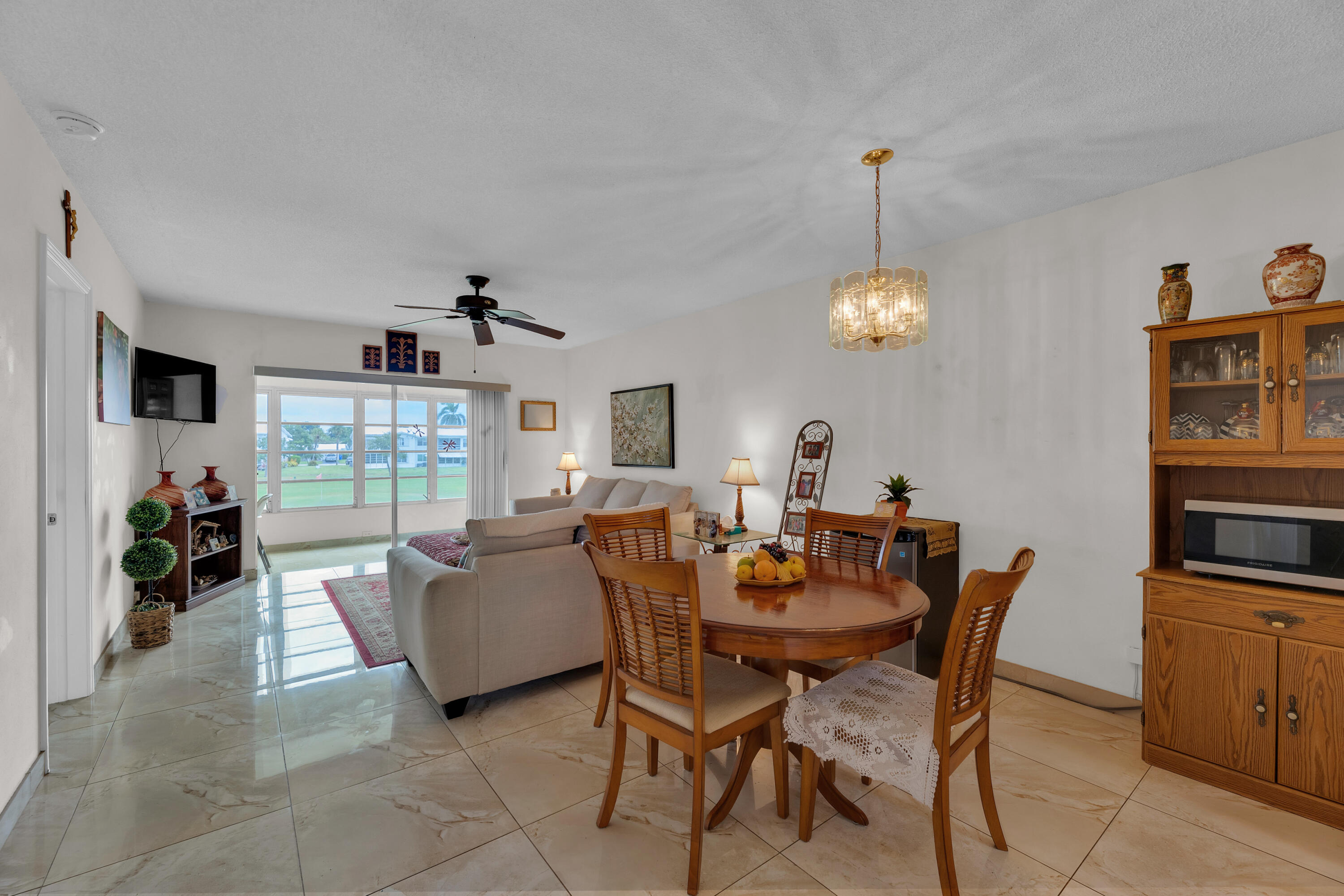 a dining room with furniture potted plants and a chandelier