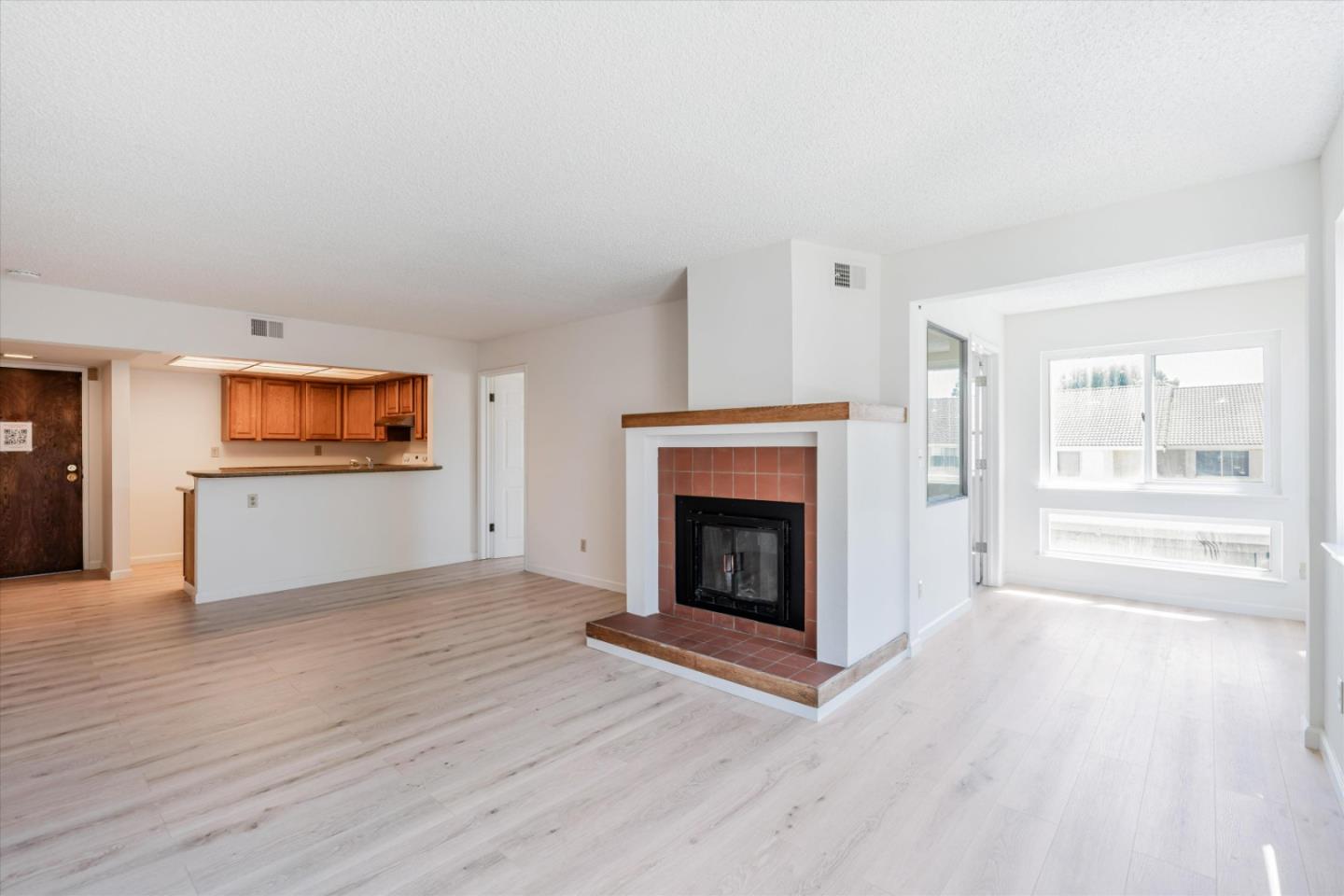 a view of a livingroom with wooden floor and a fireplace