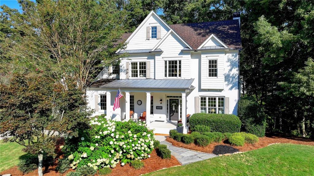 a front view of a house with a yard and potted plants