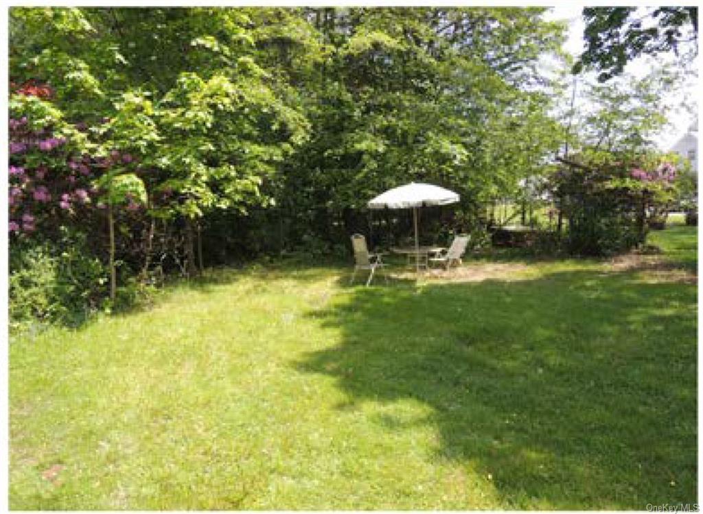 a view of a swimming pool with a table and chairs under an umbrella