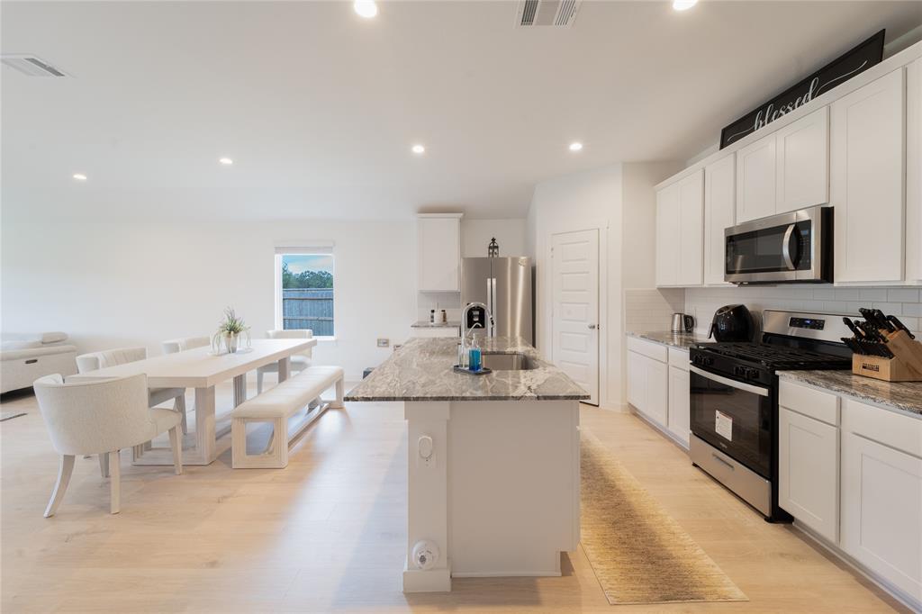 a large kitchen with stainless steel appliances lots of counter space and windows