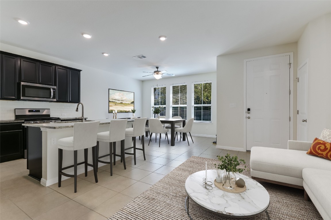 a living room with stainless steel appliances kitchen island granite countertop furniture and a view of kitchen