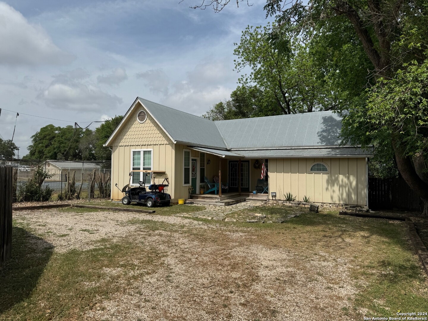 a view of a house with large outdoor space and a car parked in a yard