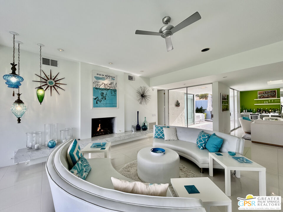 a living room with furniture a fireplace and a chandelier