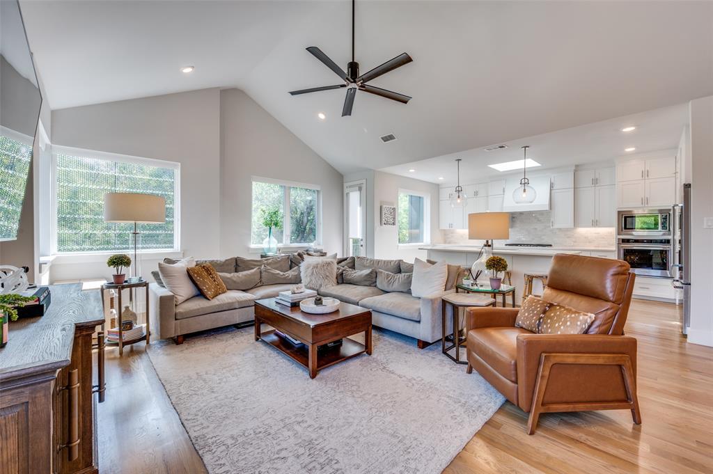 a living room with furniture kitchen view and a large window