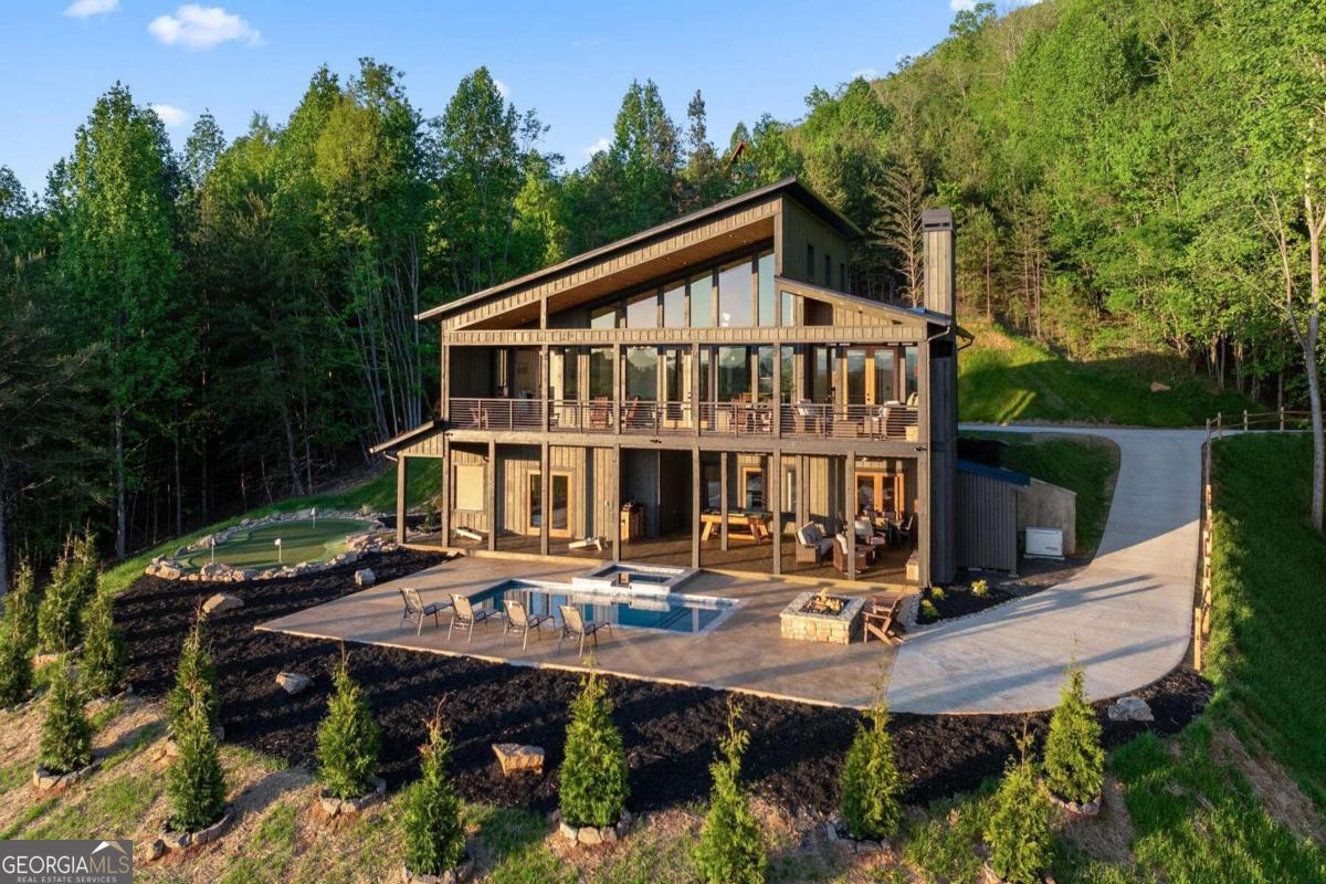 a view of a house with backyard wooden deck and sitting area