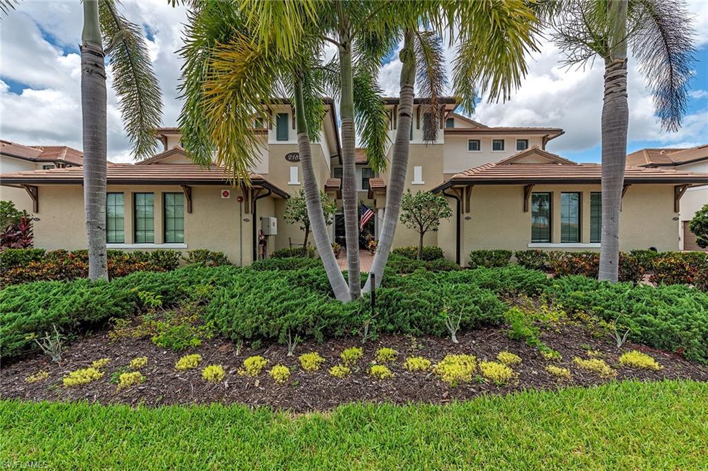 a view of a house with a yard and potted plants