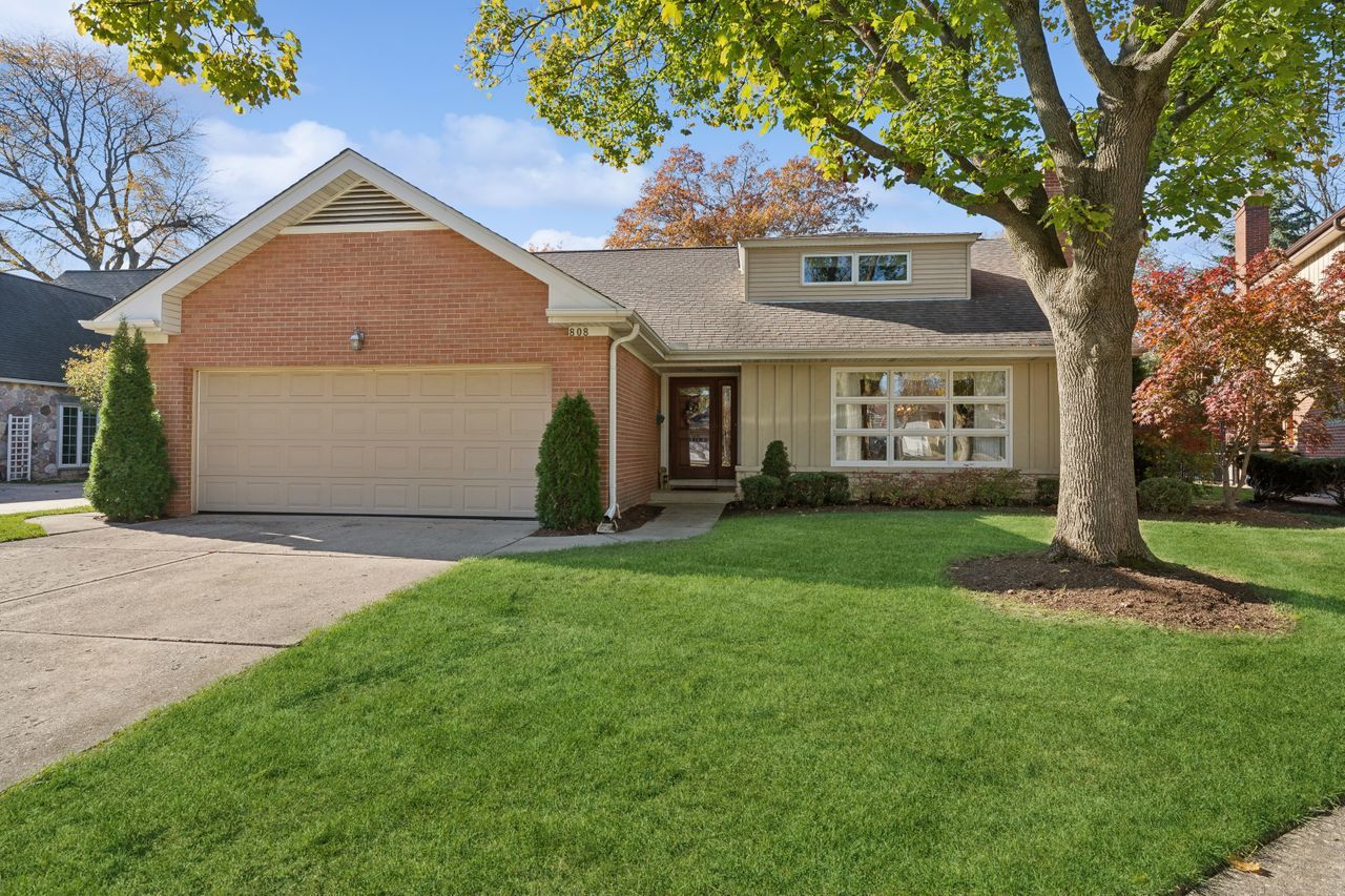 a front view of a house with a yard and trees