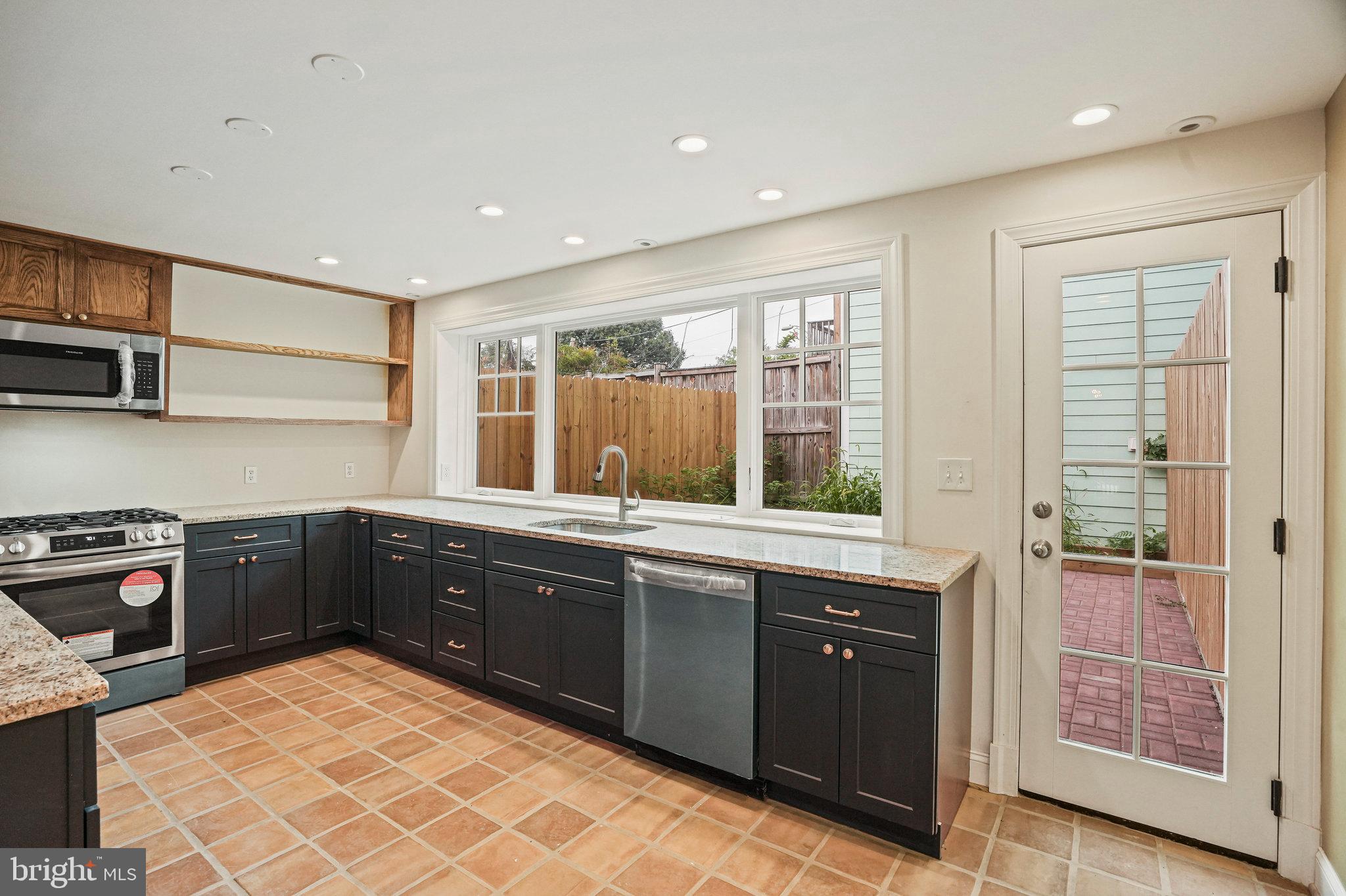 a kitchen with stainless steel appliances granite countertop a sink and wooden cabinets