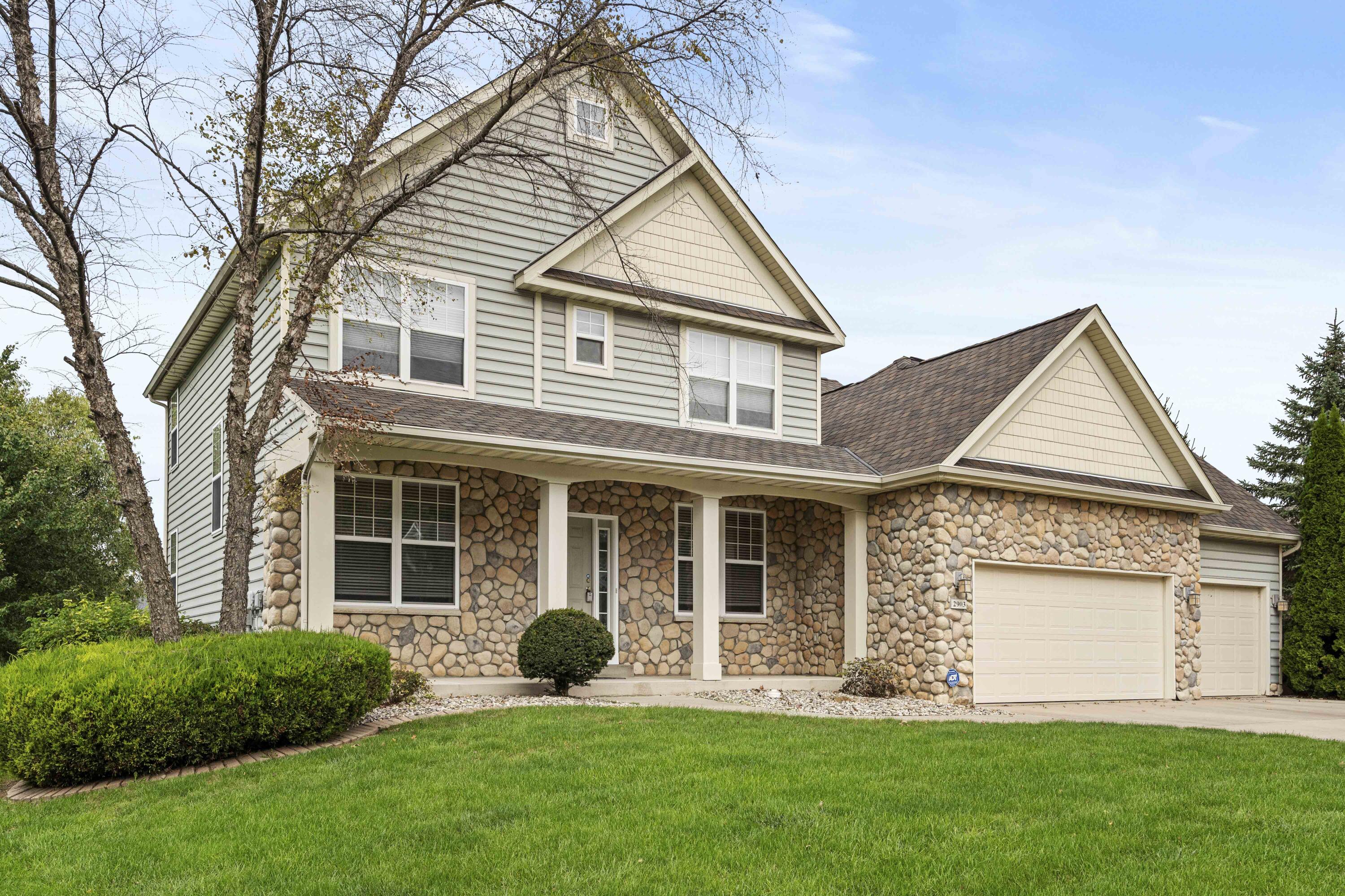 a front view of a house with a yard and garage