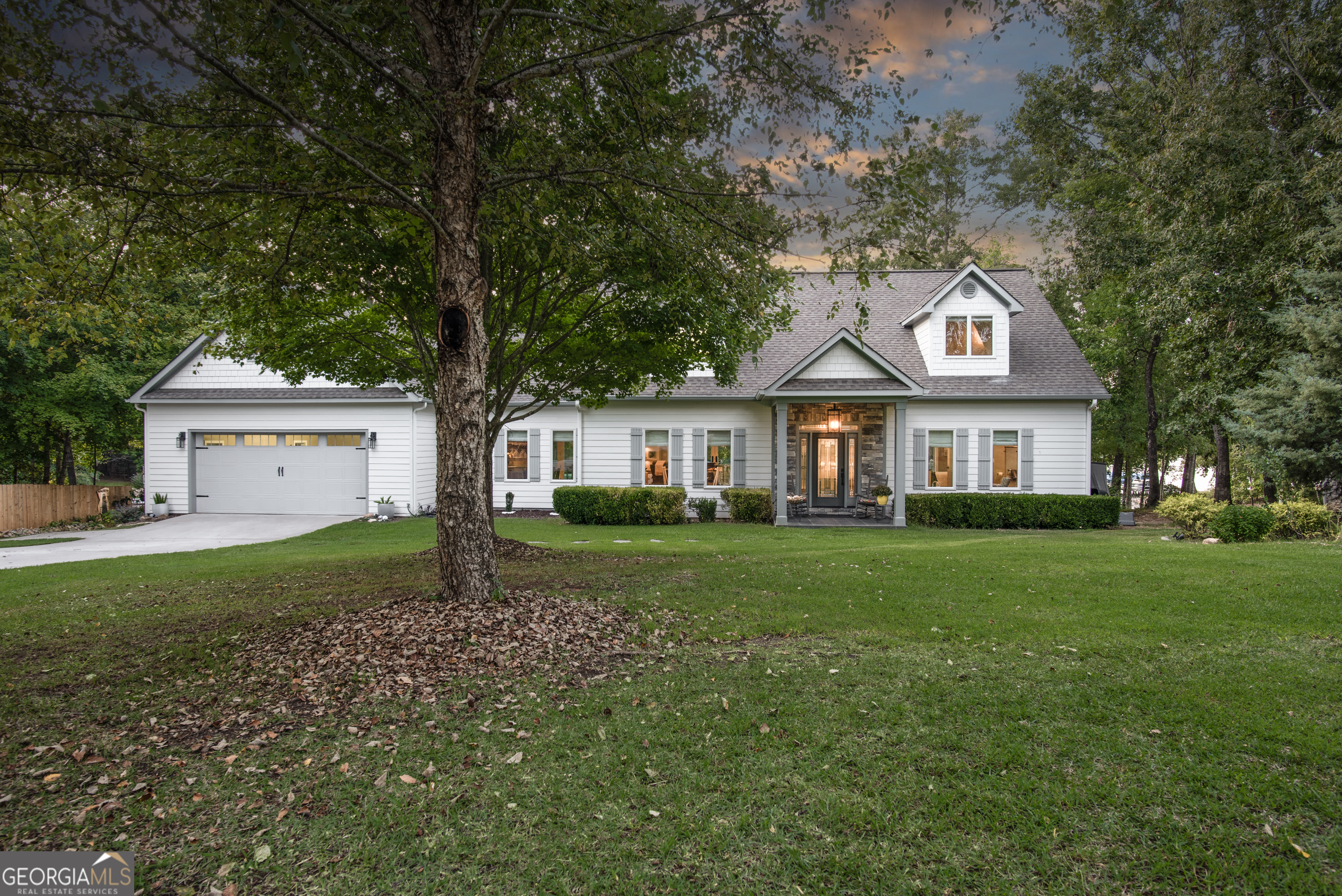 a front view of a house with a yard and trees