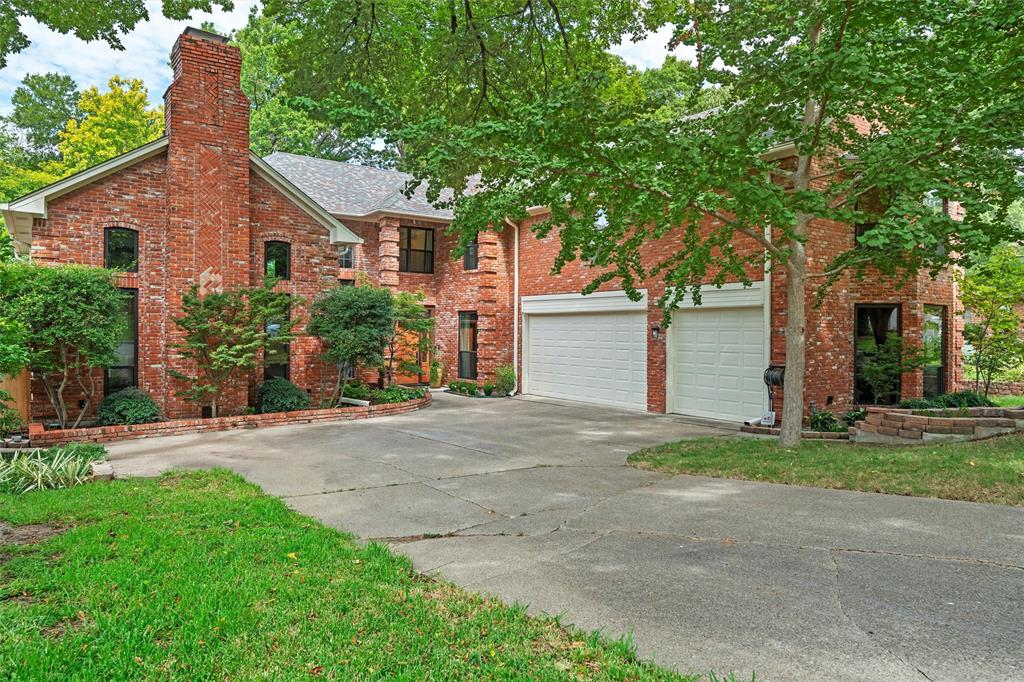 a view of a house with a yard and large tree