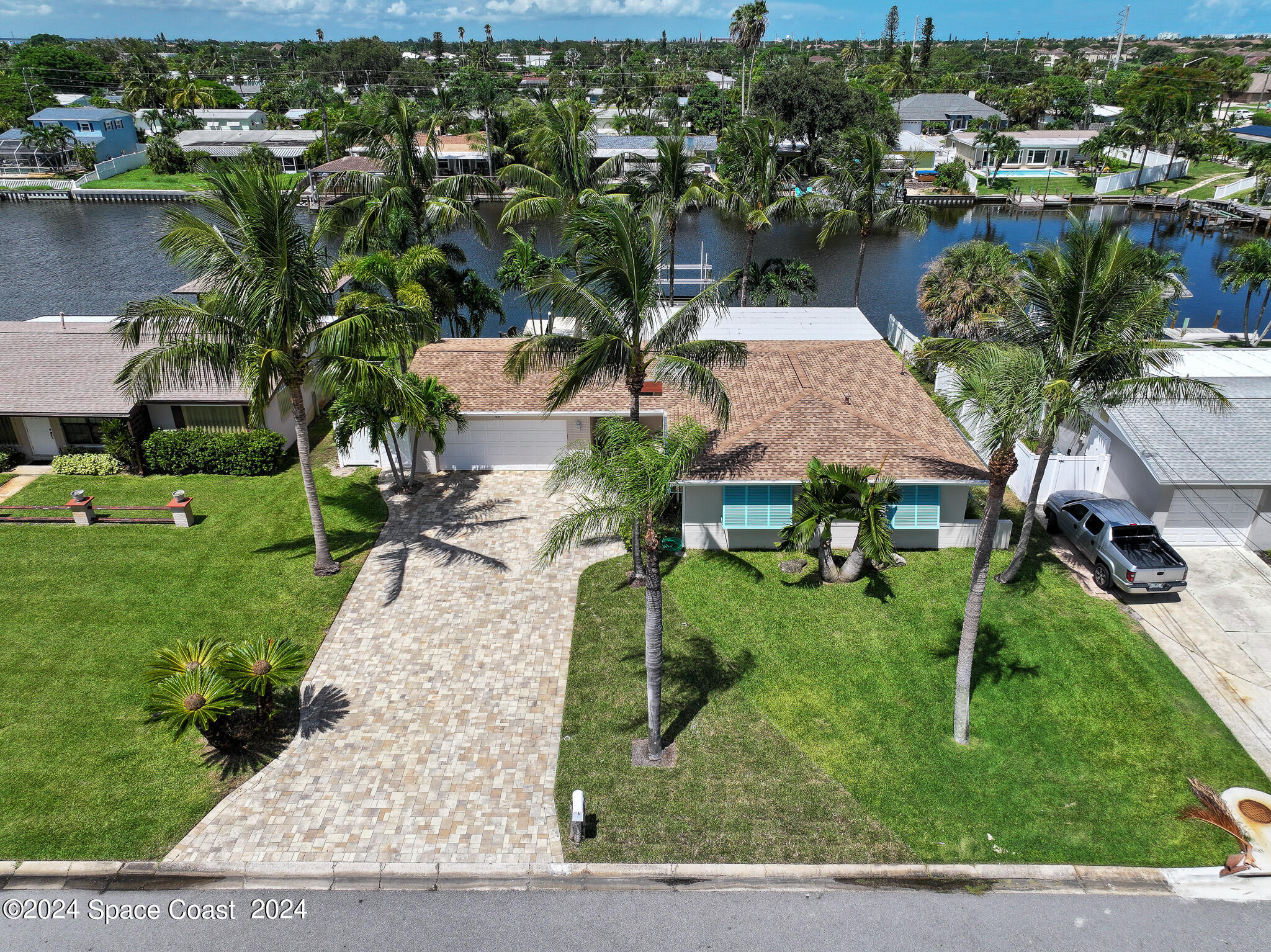 an aerial view of residential houses with outdoor space and trees