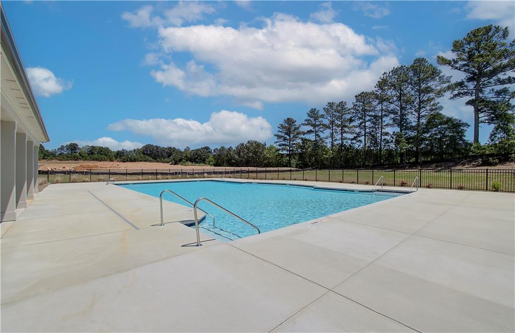 a view of swimming pool with seating space and wooden fence