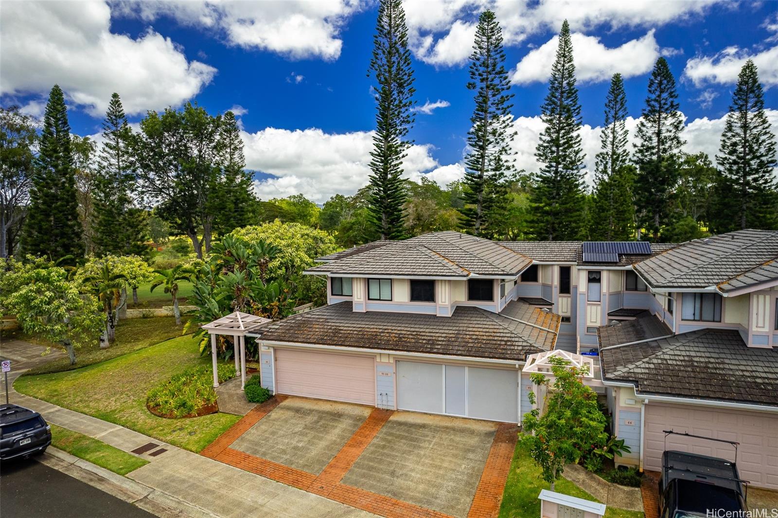 a front view of a house with a garden and trees