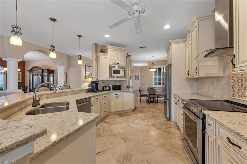 a large kitchen with kitchen island a large counter space a sink stainless steel appliances and cabinets