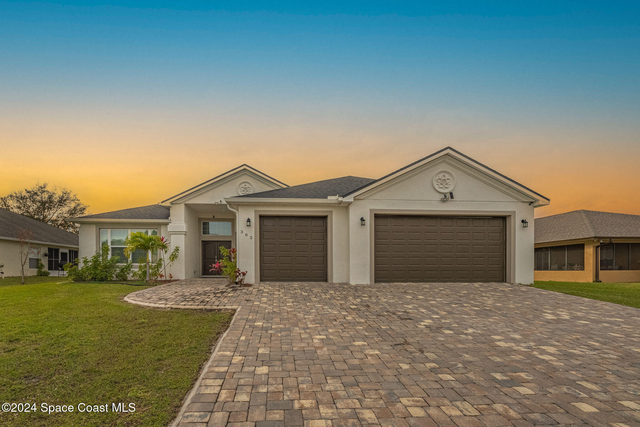 a front view of a house with yard and garage