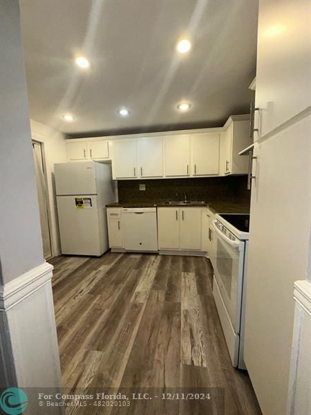 a view of a refrigerator in kitchen and utility room