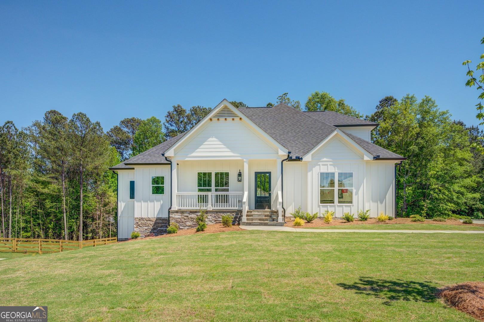 a front view of a house with a garden and trees