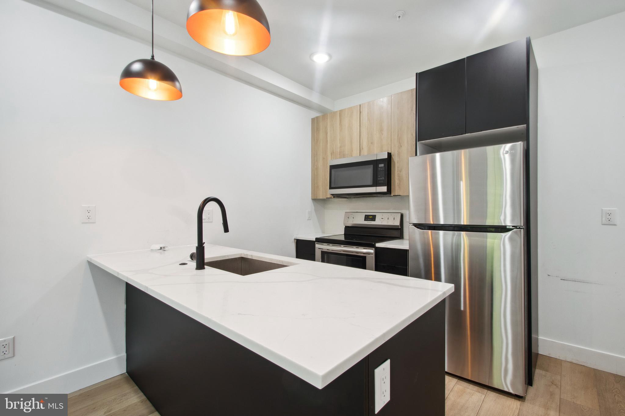 a kitchen with stainless steel appliances a refrigerator sink and microwave