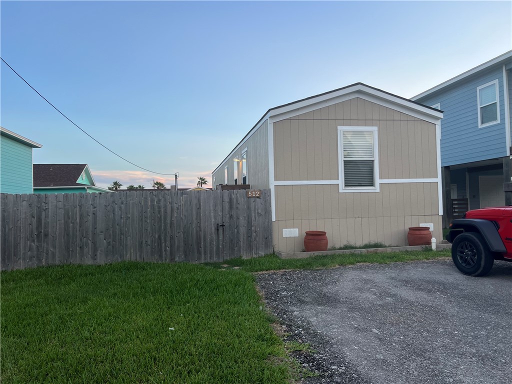 a view of a house with a yard and wooden fence