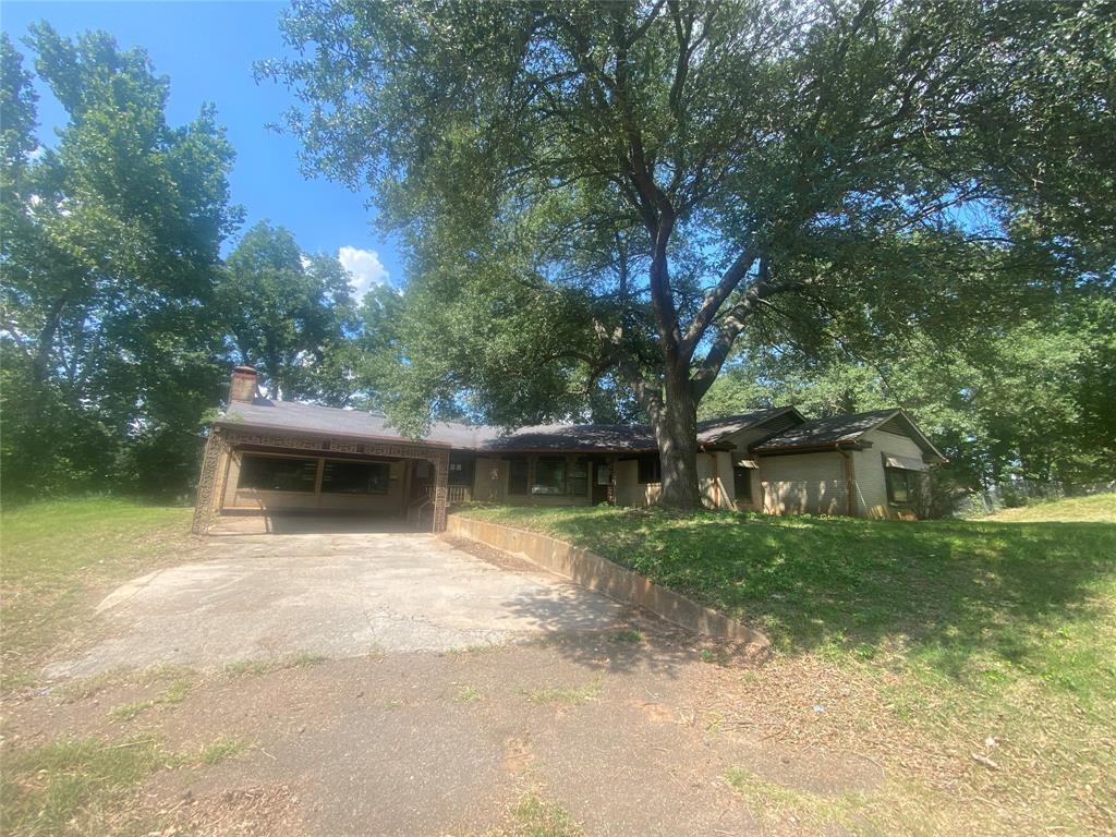 a view of house with backyard outdoor space and swimming pool