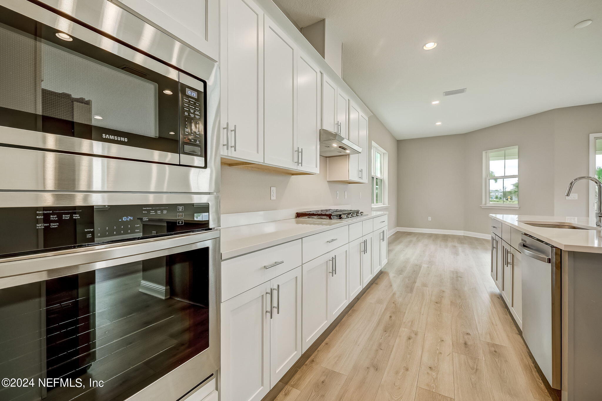 a kitchen with stainless steel appliances kitchen island granite countertop a stove a sink and a microwave