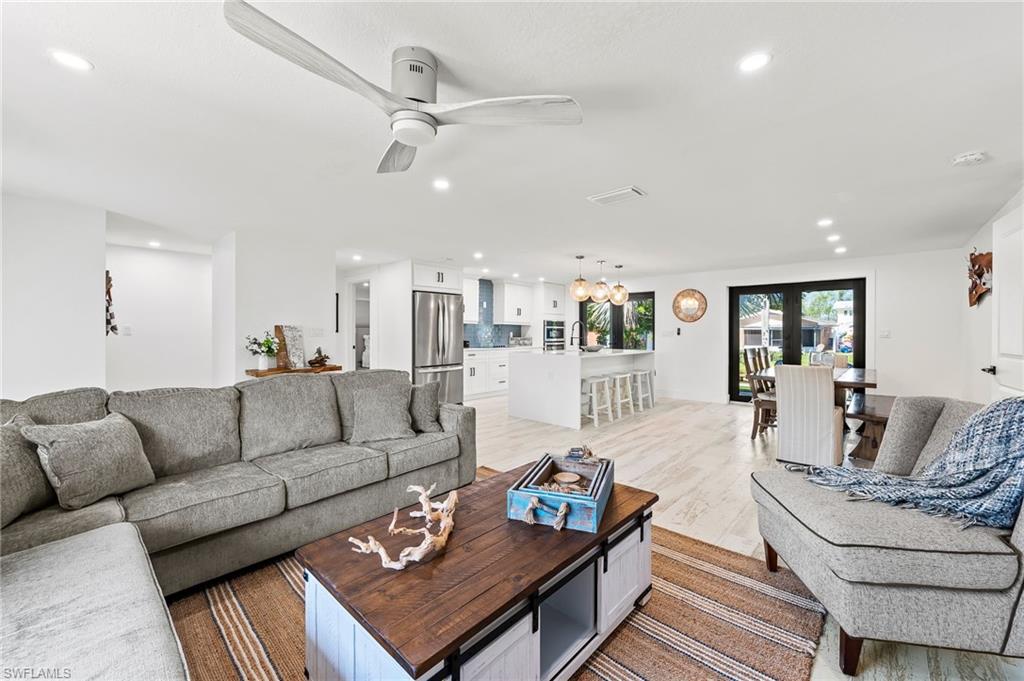 a living room with furniture and view of kitchen