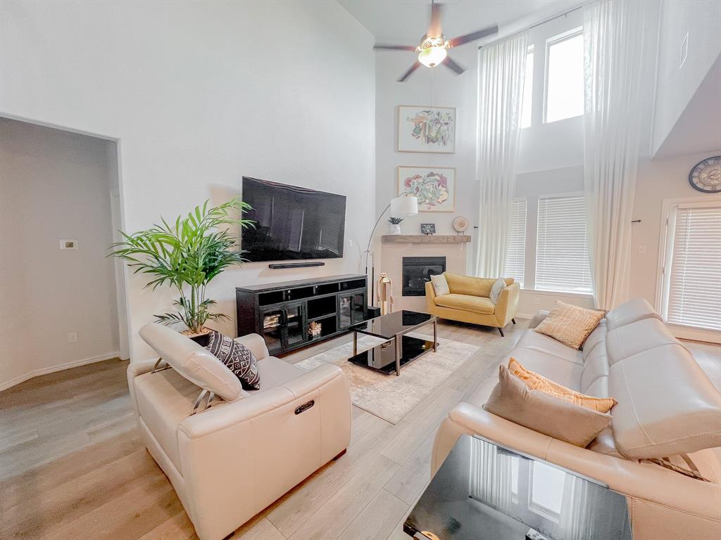 a living room with furniture a fireplace and a flat screen tv