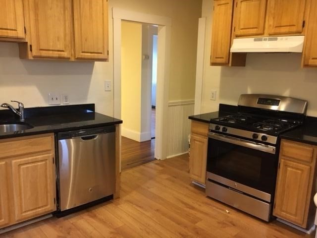 a kitchen with wooden cabinets and a stove top oven