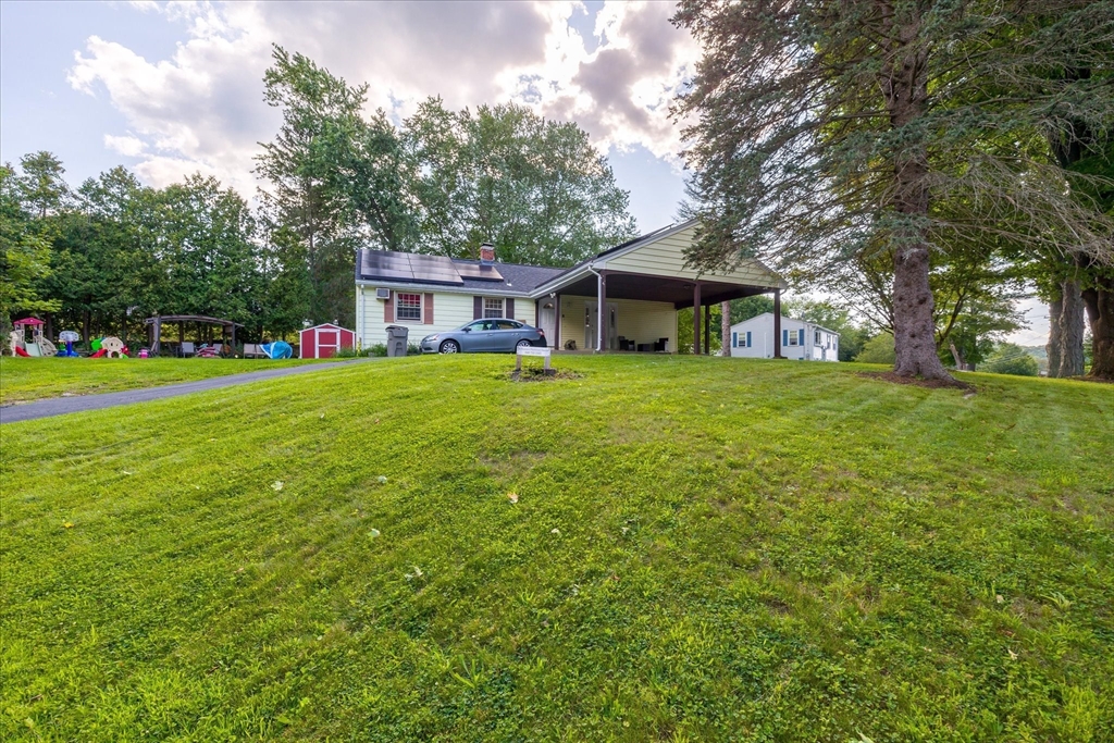 a front view of a house with a yard and trees