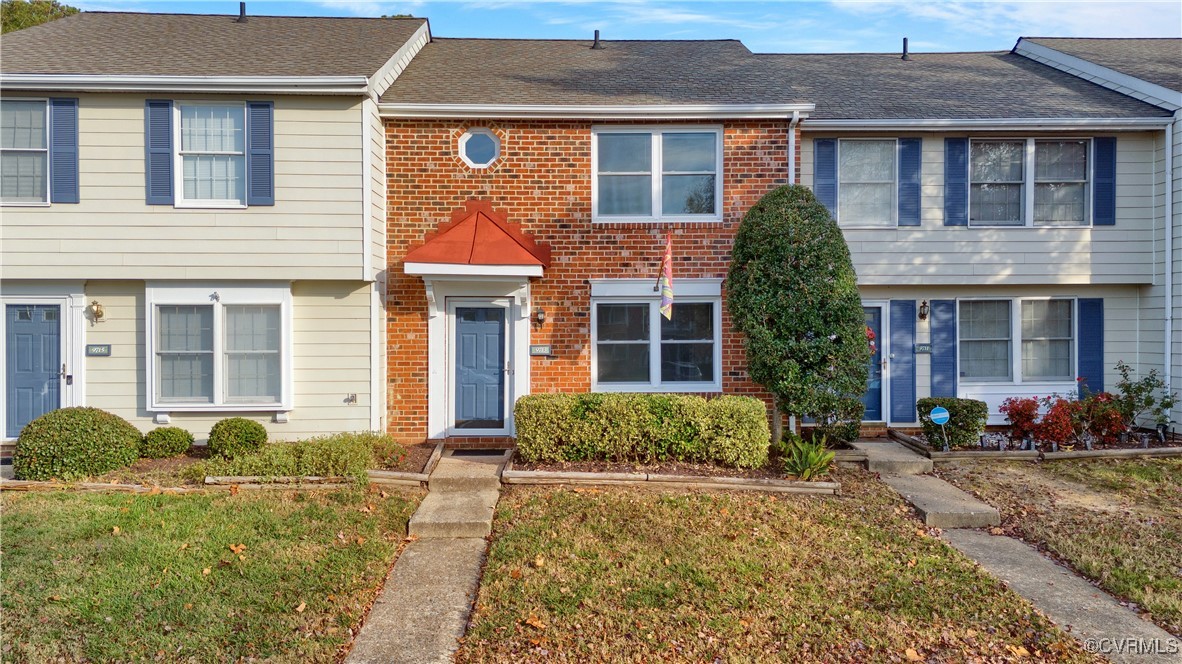 front view of a brick house with a yard