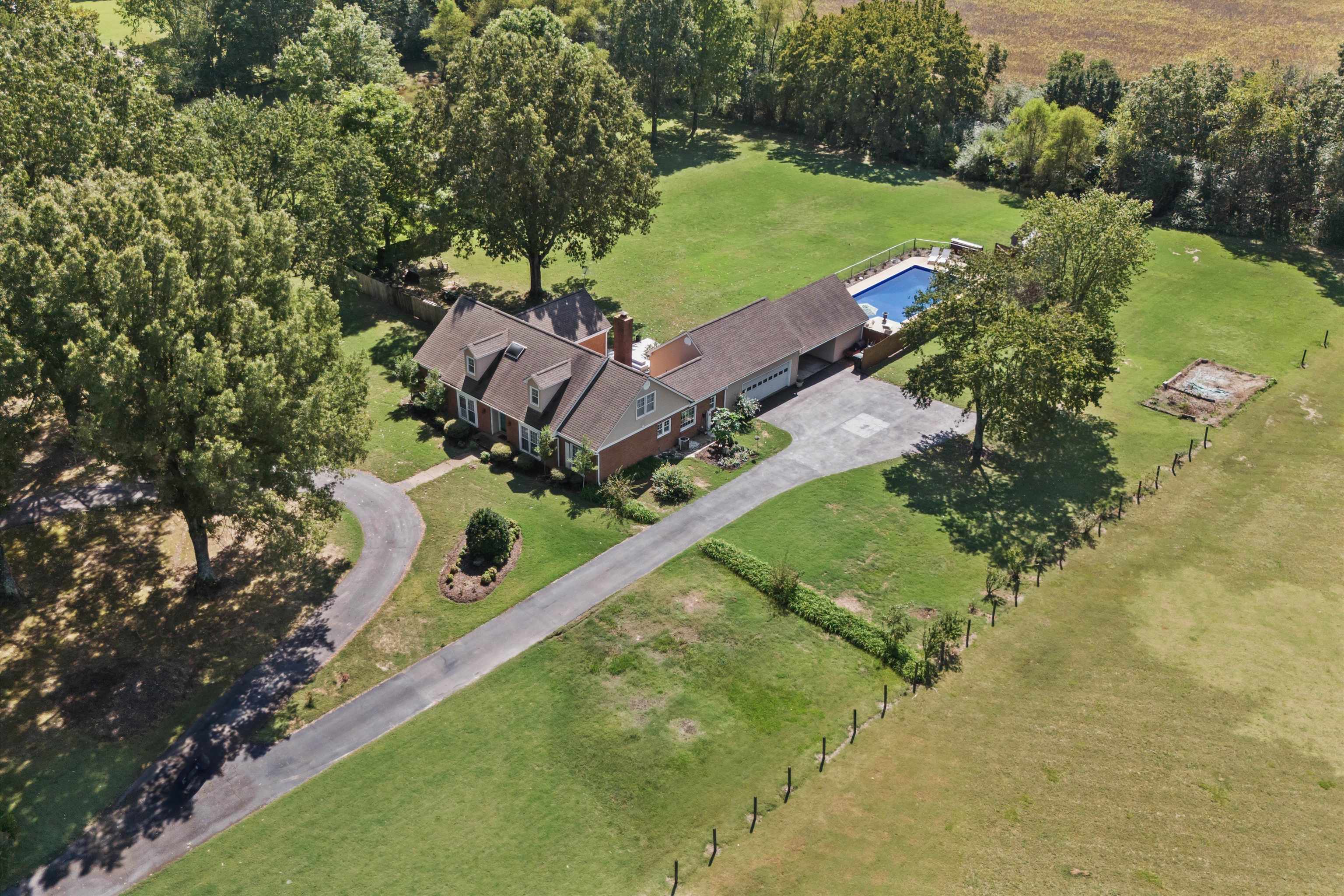 an aerial view of a house with a garden and lake view