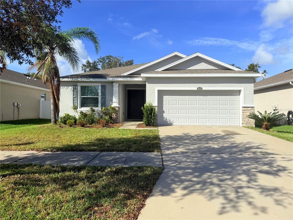 a front view of a house with a yard and garage