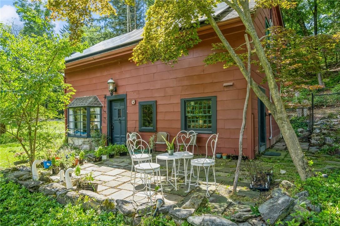 a view of a chair and table in backyard of the house