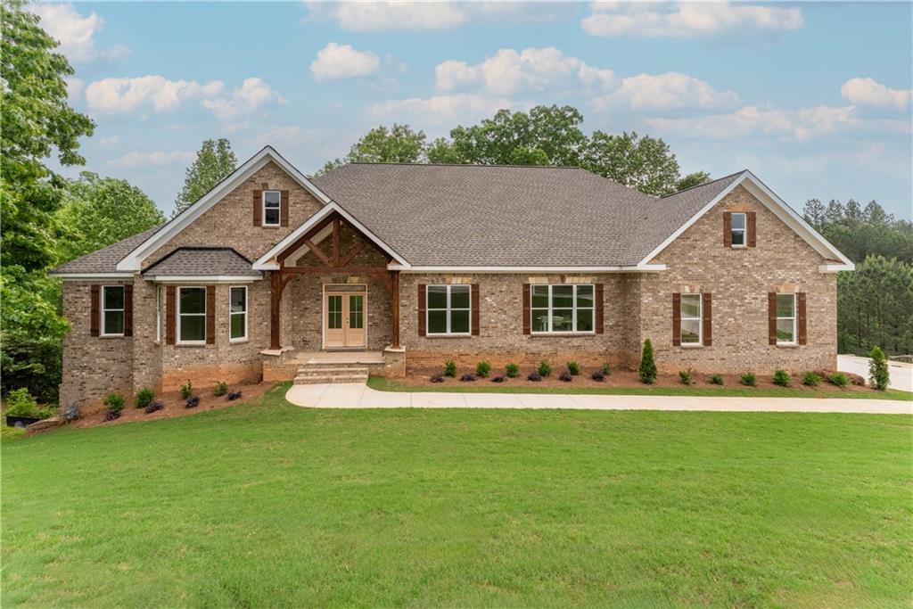 a front view of a house with a yard and trees