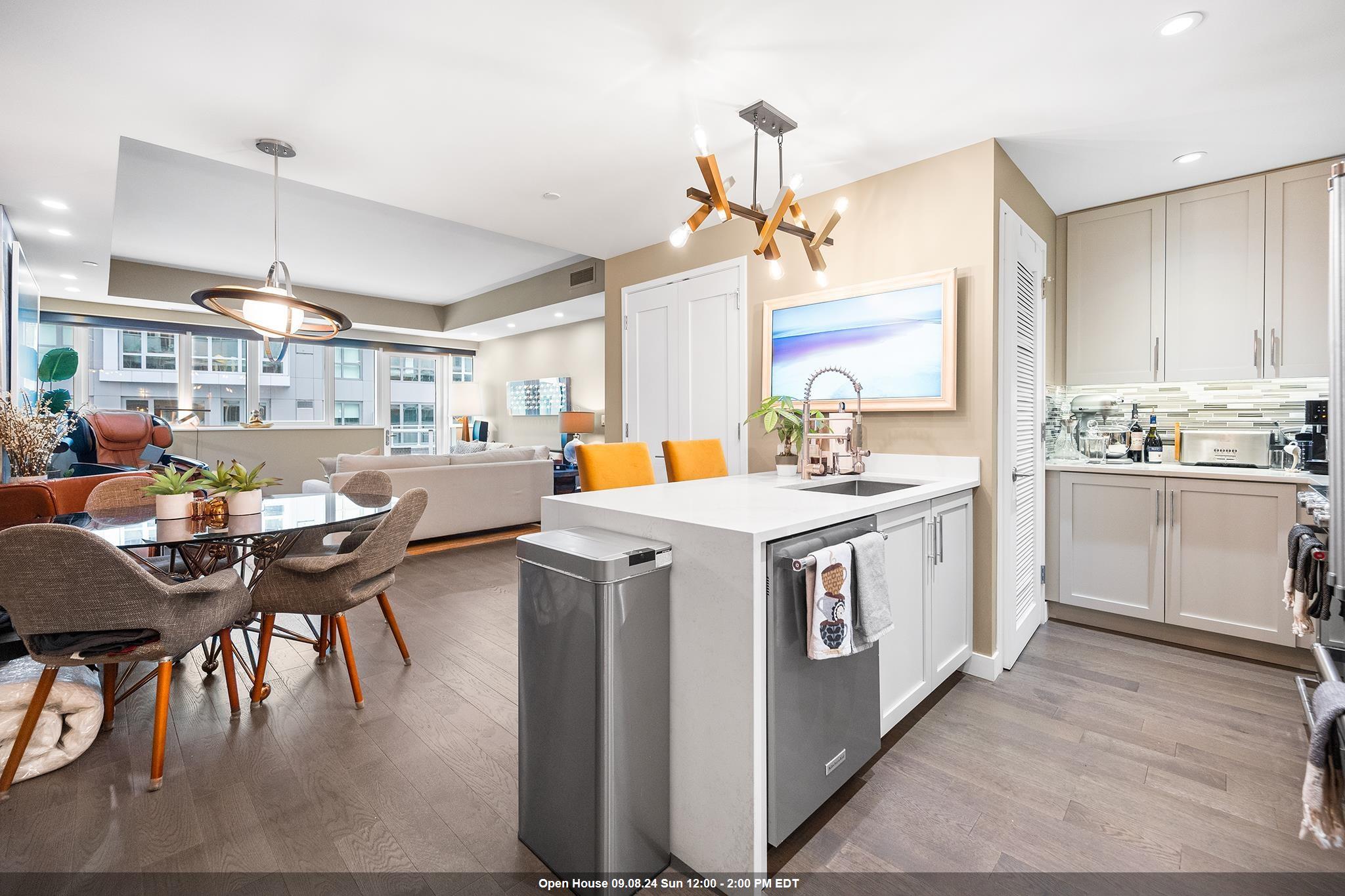 a kitchen that has a lot of cabinets a sink a stove and chairs in it