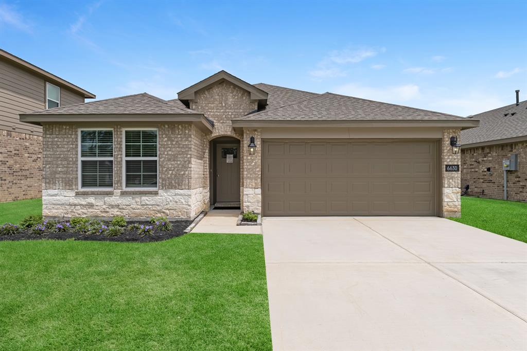 a front view of a house with a garden and yard