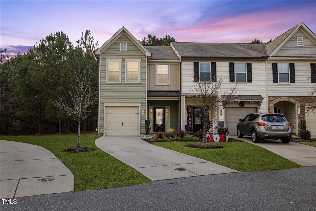 a front view of a house with a garden and yard