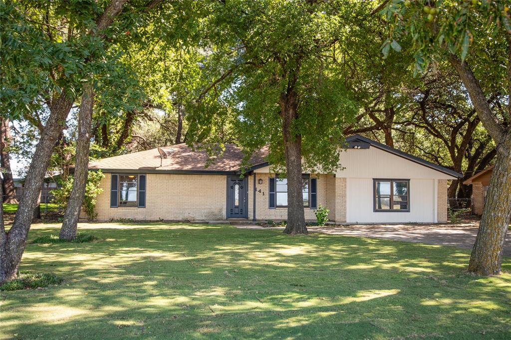 a front view of house with yard and trees