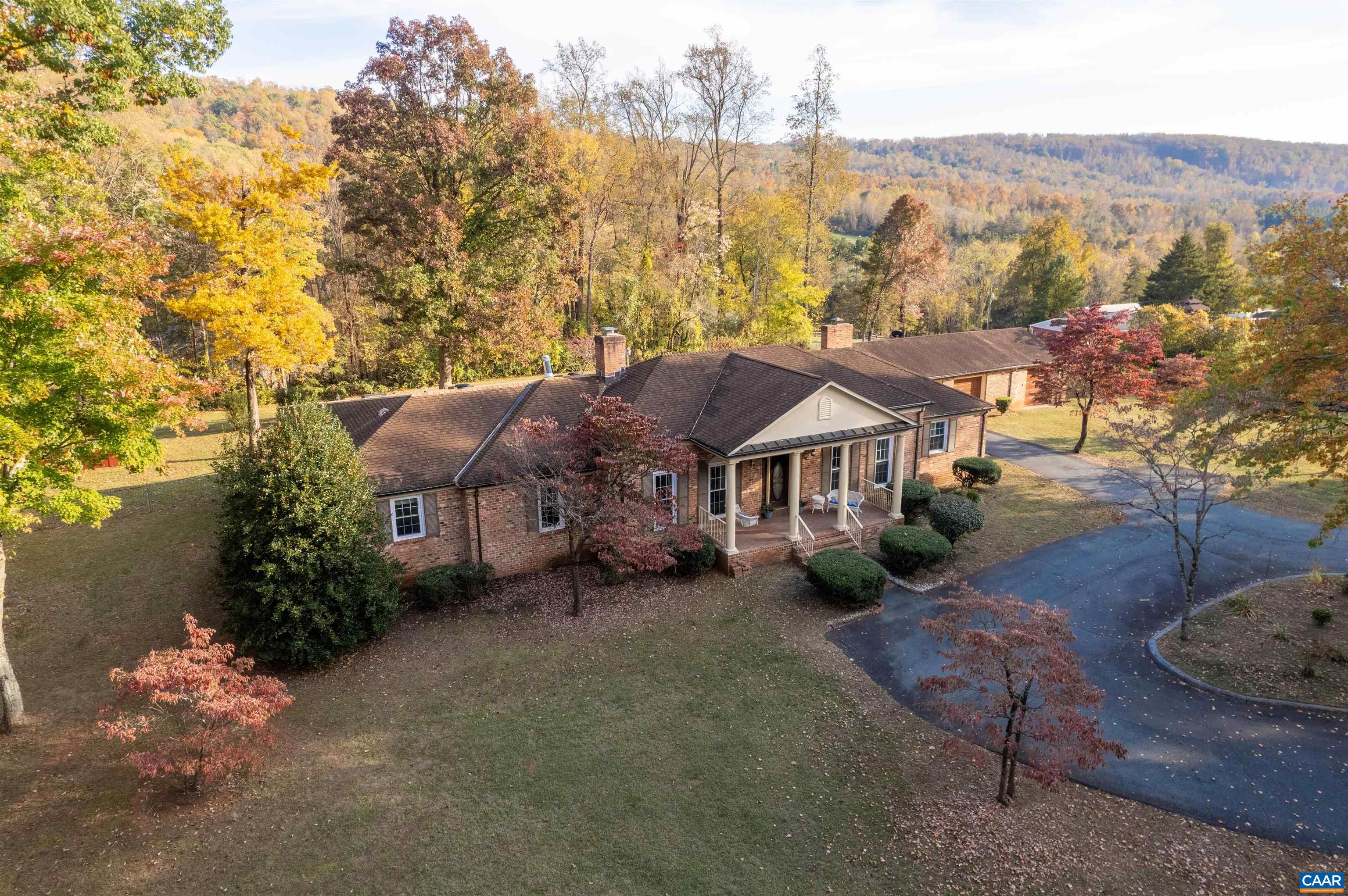 an aerial view of residential houses with outdoor space and trees