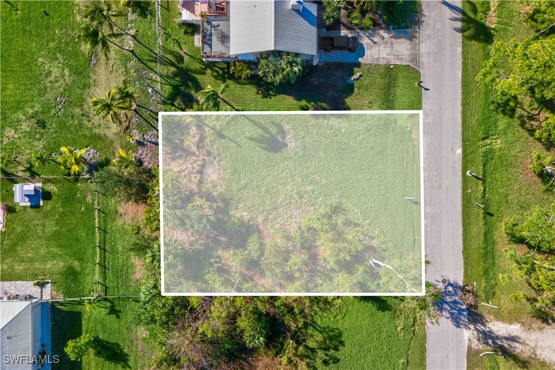 an aerial view of residential house with outdoor space and trees all around