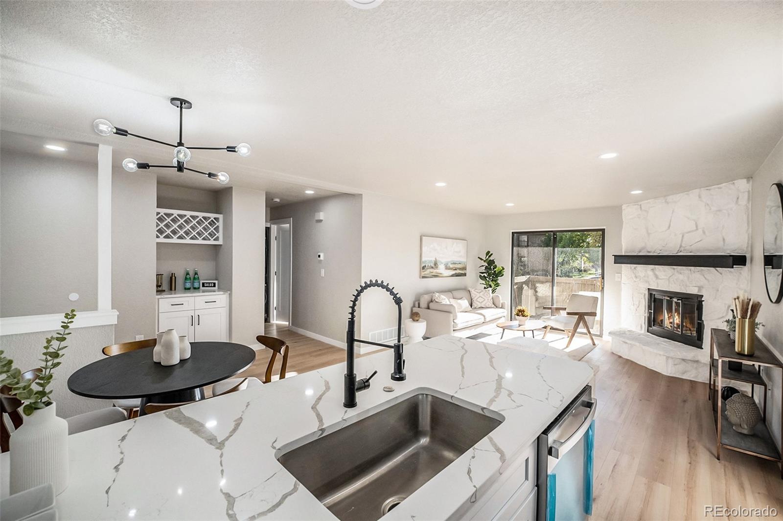 a kitchen with sink refrigerator dining table and chairs